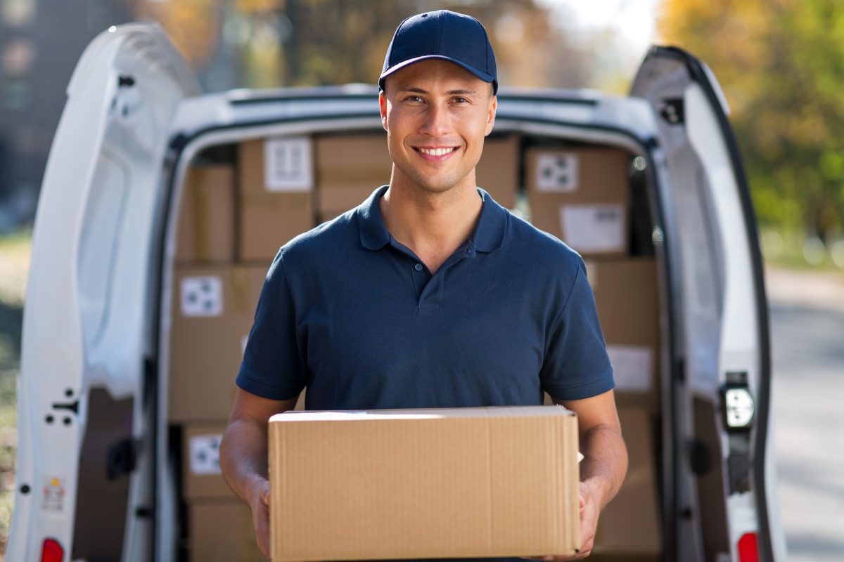 Man with package standing in fron of same day delivery van